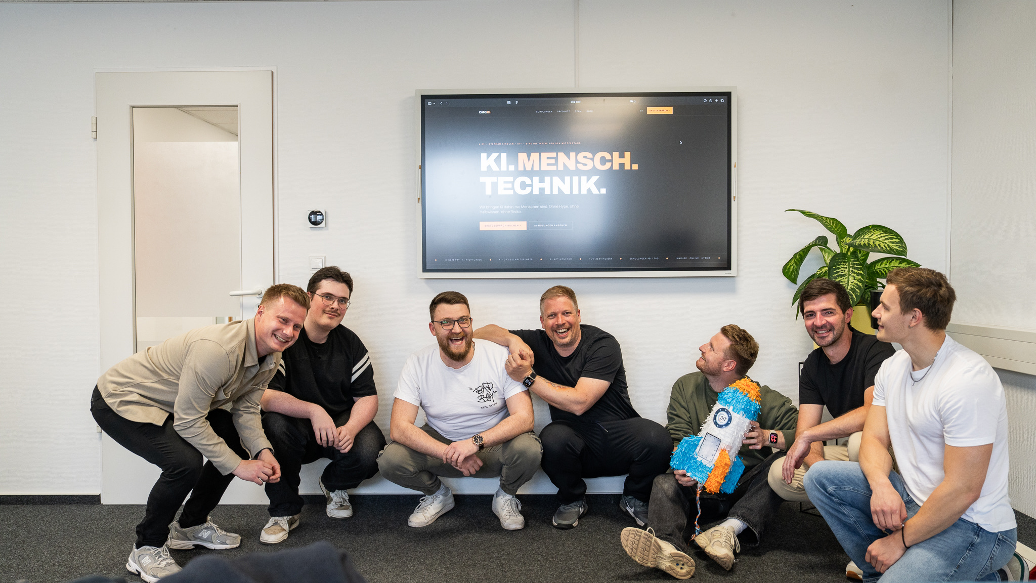 Das Team der OIT GmbH vor dem Leitbild KI. Mensch. Technik.
