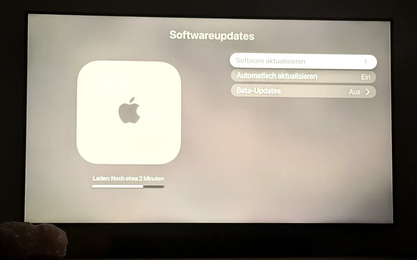Fernseher zeigt den Bildschirm Softwareupdates des Apple TV waehrend das Update tvOS 27 geladen wird